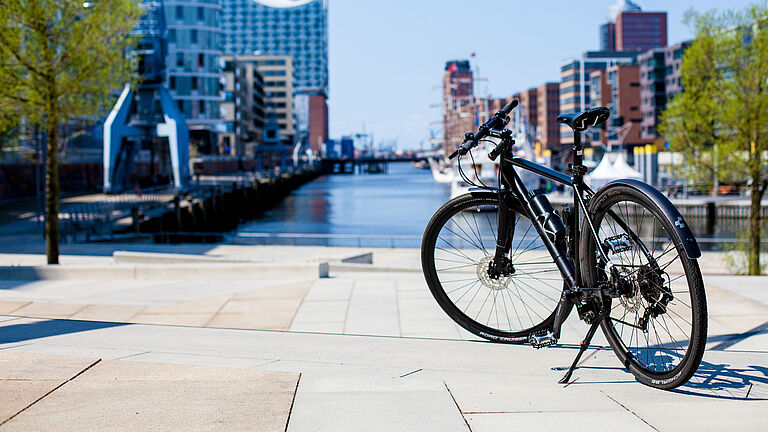 Ein Fahrrad in der Speicherstadt, man sieht einen Kanal und im Hintergrund die Elbhilhramonie