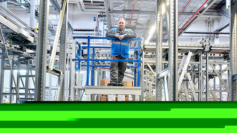Schichtleiter Christian Appel steht auf einer Podestleiter.
