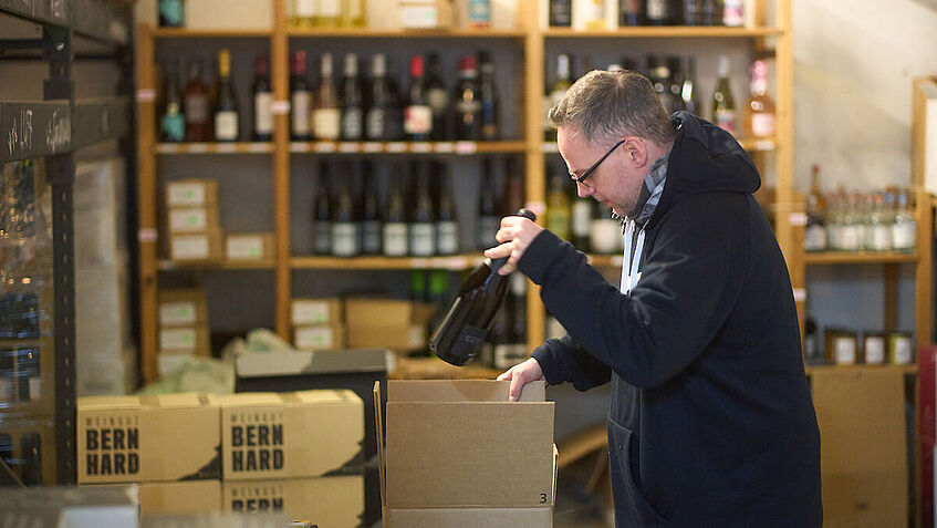 Steven Wedhorn verpackt Weinflaschen in Postpakete.