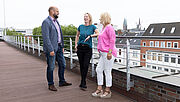 Drei Mitarbeitende der Regionaldirektion in Bremen stehen auf der Dachterrasse