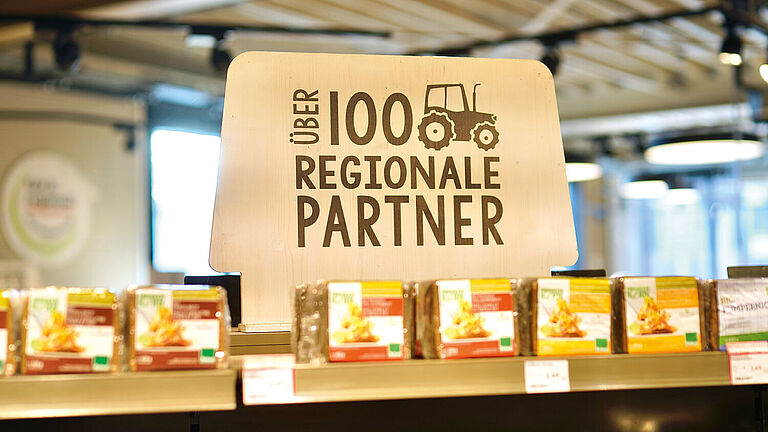"Über 100 regionale Partner" steht auf einem hölzernen Schild in der Bio Company Filiale.