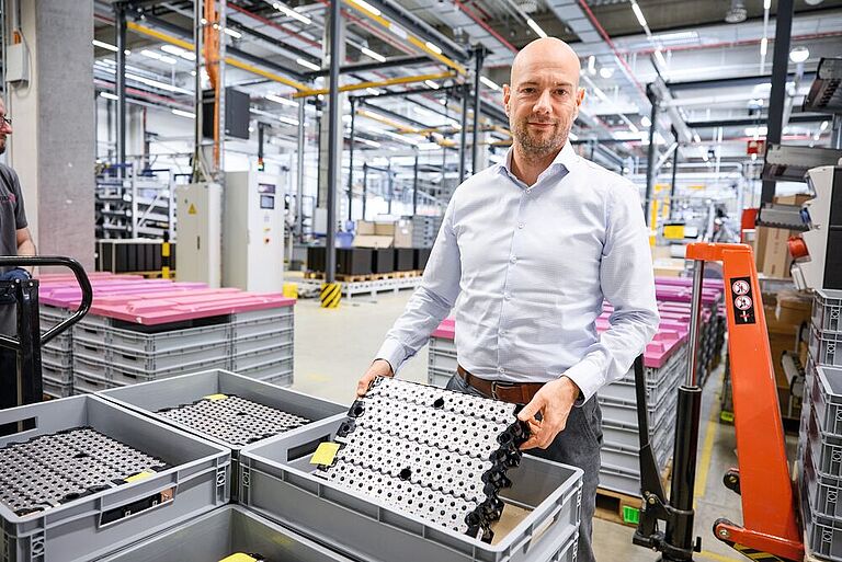Wolfgang Klüpfel zeigt ein Lithium-Ionen-Batterien-Modul in der Produktionshalle