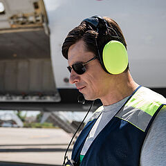 Ein Luftfracht-Mitarbeiter am Flughafen trägt eine Sonnenbrille und checkt seine Unterlagen