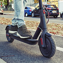 Ein E-Scooterfahrer fährt auf dem Radweg
