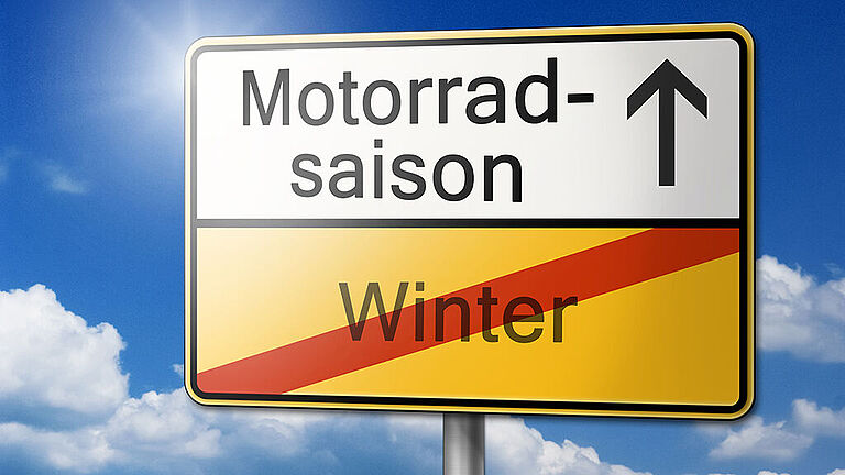 Ein Schild zeigt: Der Winter ist vorbei. Die Motorradsaison beginnt.