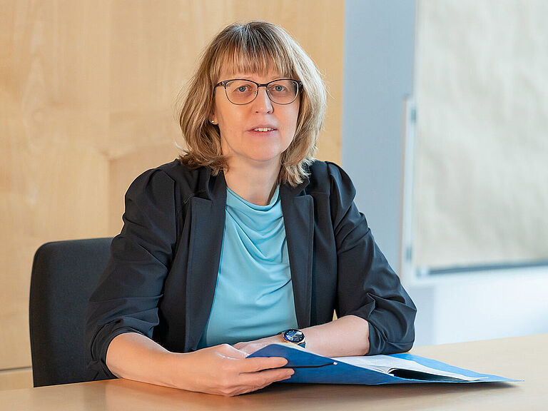 Bettina Wenig sitzt am Schreibtisch.