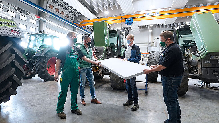 Gruppe in der Werkstatt Vier Männer unterhalten sich über Schallabsorber