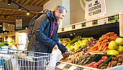 Ein Kunde bedient sich an der Obst- und Gemüsetheke im Supermarkt der Bio Company.