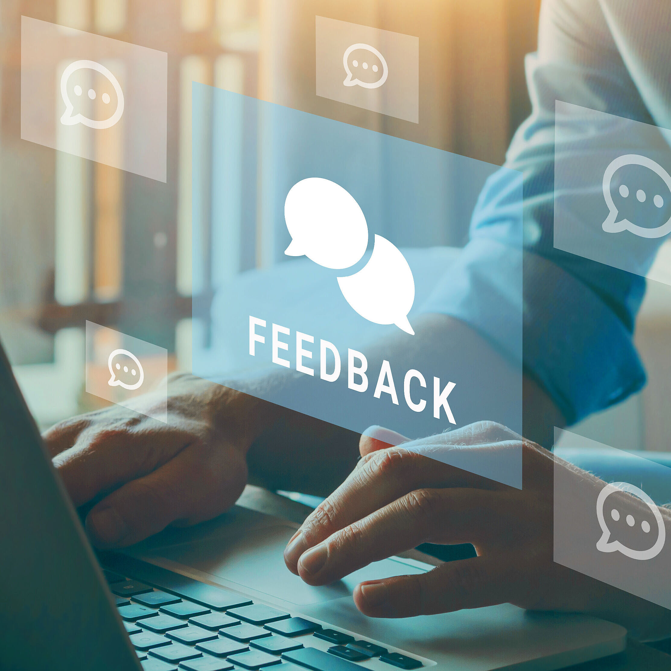 Person tippt auf Laptop, Feedback-Symbole schweben dazwischen.