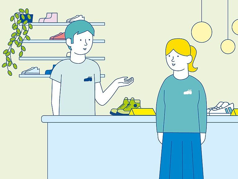 Unternehmer eins Schuhgeschäftes steht hinter dem Verkaufstresen. Er spricht mit Mitarbeiterin. Dies steht vor dem Tresen.