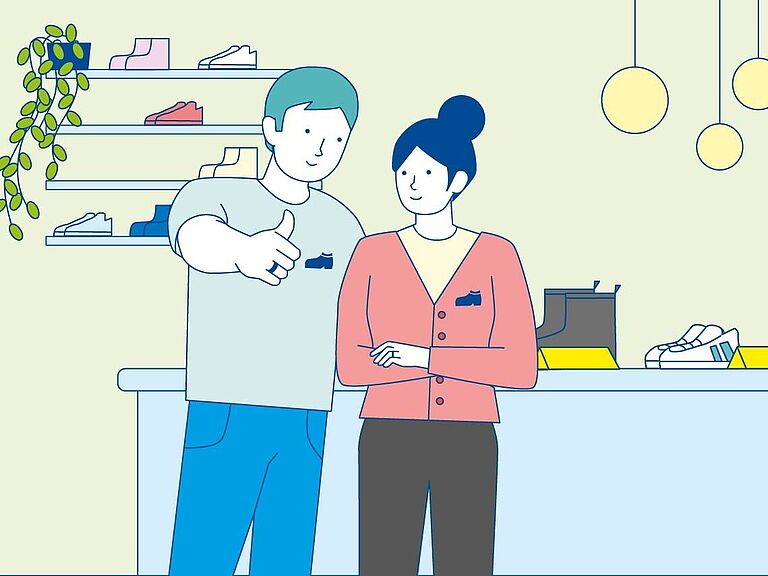 Unternehmer und Unternehmerin stehen im eigenen Schuhgeschäft.
