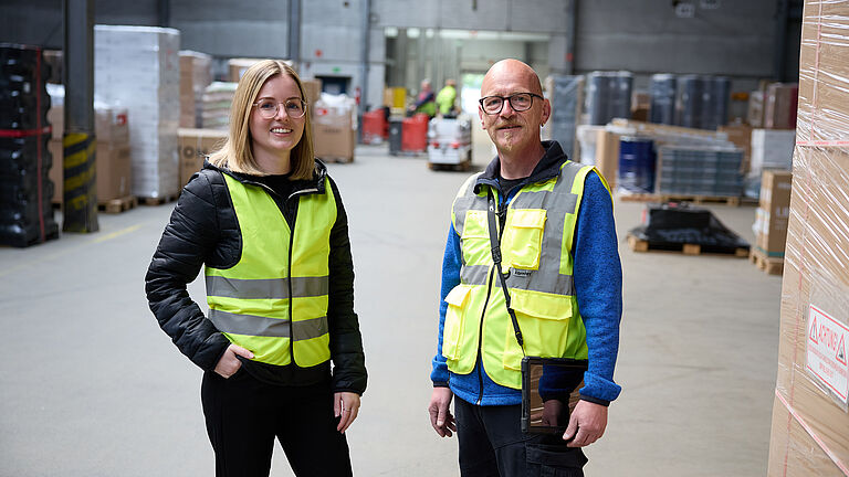 Tessa Erzgräber und Michael Schneider in Warnwesten im Umschlagslager der Zufall Logistics Group in Fulda.